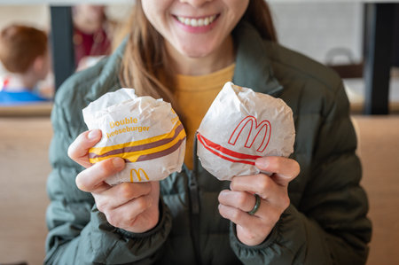 Chiang Rai, Thailand : January-17-2026 : Happiness Asian woman holding McDonald's hamburger in hands...