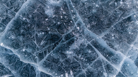 Beautiful cracks surface of the frozen lake of Baikal lake with frost methane bubbles in winter...
