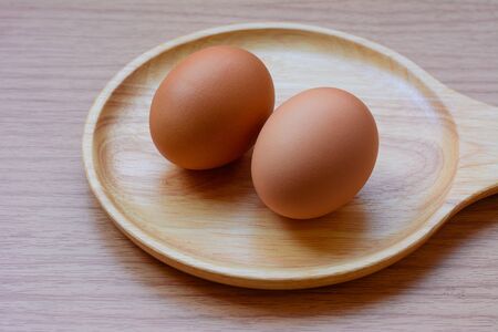 Eggs in plate on  wooden backgroundの写真素材