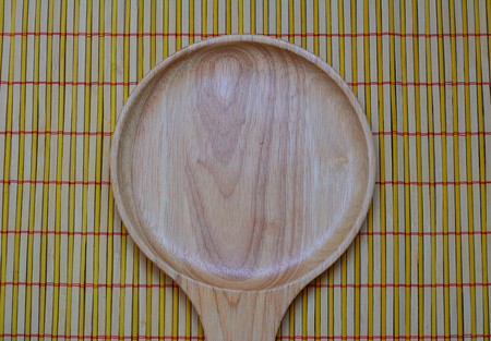The brown wooden plate on a rustic table closeup.の写真素材
