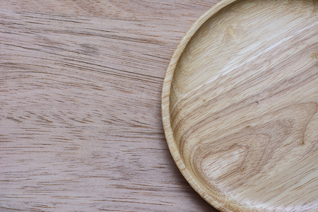 The brown wooden plate on a rustic table closeup.の写真素材