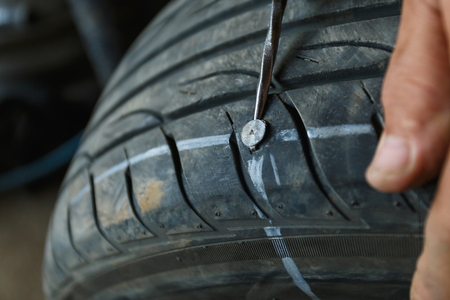 Tire leak tire drilled with a metal screw nail.の写真素材