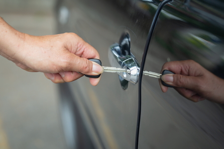 Close up of human male hand opening car door,unlock a door car by key.の写真素材
