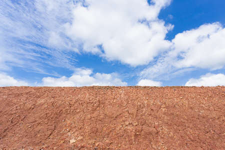 Background landscape of blue sky with clouds over cracked desert earth
