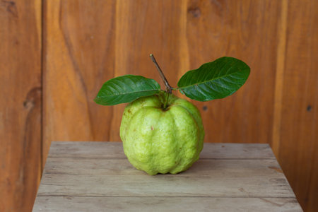 Fresh guava fruit with green leaf on wooden table, stock photoの写真素材