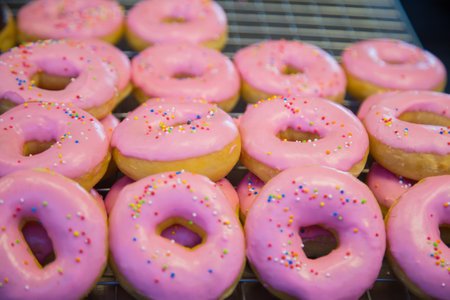 Delicious donuts with pink icing and sprinkles on top.の写真素材