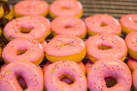Delicious donuts with pink frosting and colorful sprinkles, Street Food.の写真素材