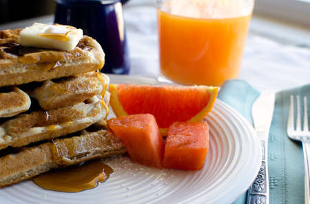 Breakfast plate of fresh waffles with syrup and fruit の写真素材