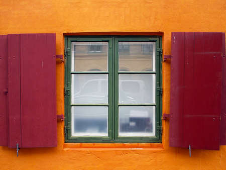 Colorful red shutters on a European building の写真素材