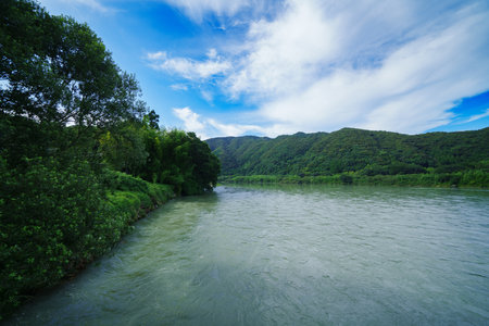 Landscape of the river and mountains under the blue sky with clouds