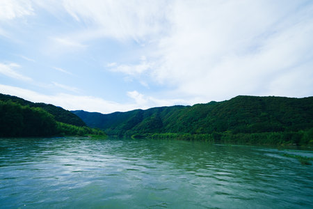 Mountain landscape with a river, blue sky and white clouds at Shimanto riverの写真素材