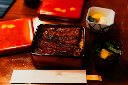 Grilled eel in a black plate on a wooden table.の写真素材