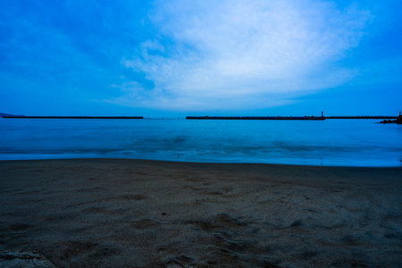 Long exposure of the sea and beach with blue sky at dusk.の写真素材