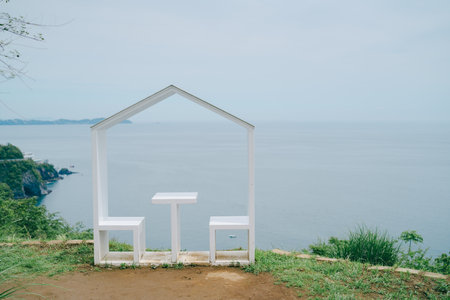 White chair and white table on the beach with sea and sky backgroundの写真素材