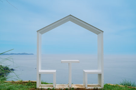 White chair on the grass with sea view background and blue sky.の写真素材