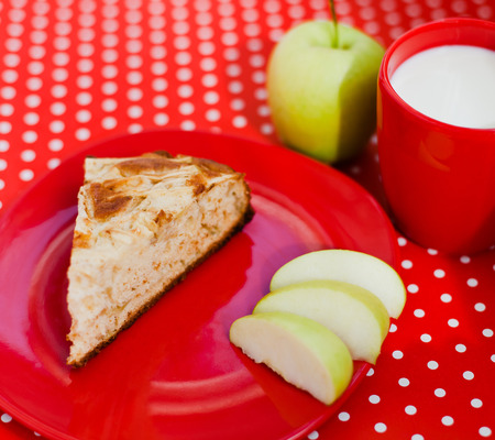 Homemade baking apple pie with cup of milk on the red backgroundの写真素材
