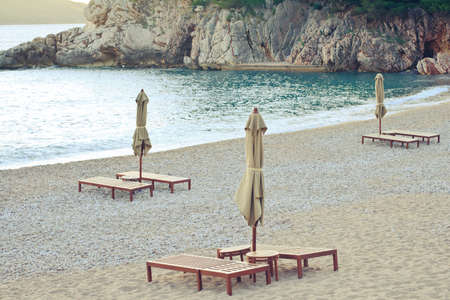 Beautiful sea view with rocks, sunbeds and umbrellasの写真素材