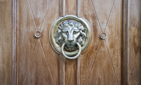 A brown door with beautiful bronze retro style carved lion head handle  knocker の写真素材