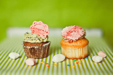 Two cupcakes and candies on the green の写真素材
