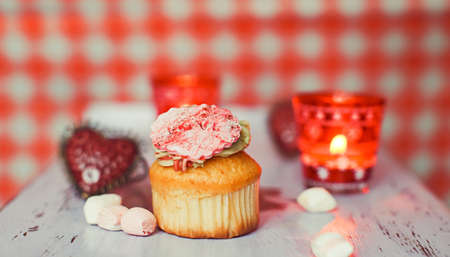 Cupcake with candies, heart and candleの写真素材