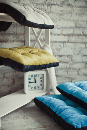 Colored pet matresses on a rack with clockの写真素材
