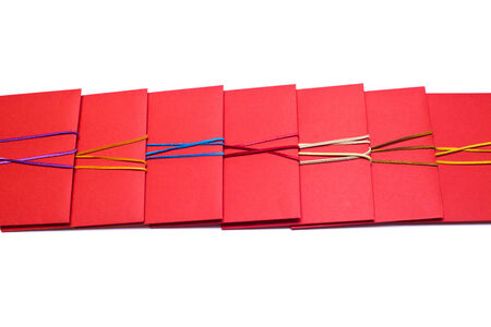 Row of red envelopes with coloured ribbons isolated on whiteの写真素材