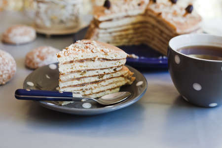 Closeup piece of a cake with tea in grey cupの写真素材