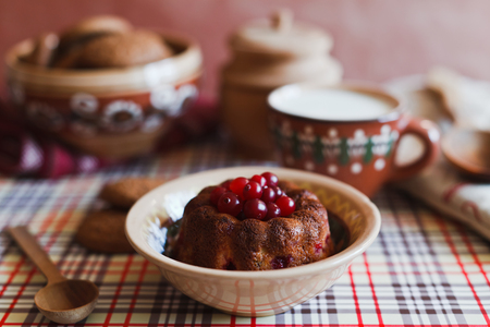 Cranberry cake on the red plate with spoon and cup of milkの写真素材