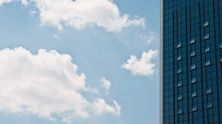 Part of business center in front of the blue sky with cloudsの写真素材