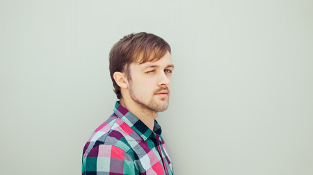 Young winked man in coloured shirtの写真素材