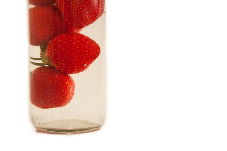 Fresh strawberry in the bottle with water isolated on white backgroundの写真素材