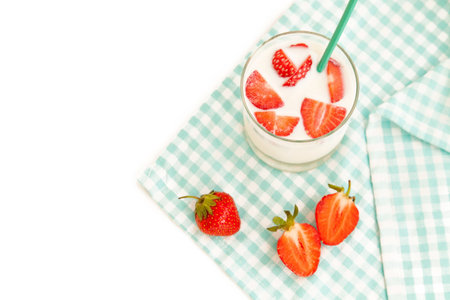 Summer background: tasty ripe strawberry and cup of milk isolated on white backgroundの写真素材
