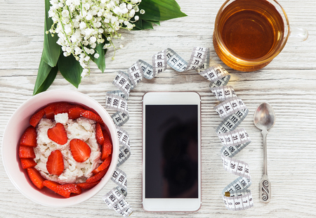 Phone fitness application and light breakfast on wooden tableの写真素材