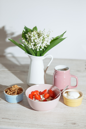 Light breakfast with strawberries, cottage cheese, flakes and teaの写真素材