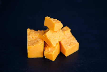 Cheese in peaces on the black background horizontalの写真素材