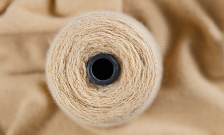 Nude colour skein on the knited textile background