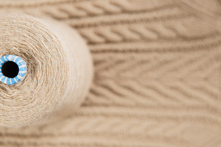 Nude colour skein on the knited textile background
