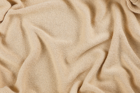 Industrial knitted textile in beige color as background