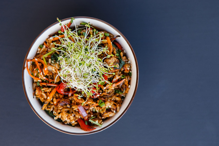 Plate of wok vegetable rice with microgreen on the dark backgroundの写真素材