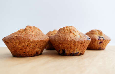 Freshly baked cupcakes muffins on a light brown crafted parchment. Home-made pastries as cooking or baking concept.の写真素材