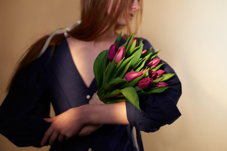 Tulip flowers. Long hair woman holding beautiful spring bouquet of tulips. March 8, Mother's Day or International Woman's Day conceptの写真素材