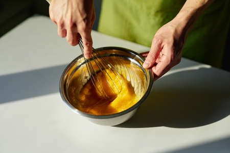 Tasty homemade cakes baking, Easter pie preparing or cookie concept. Chef in green apron mixing...