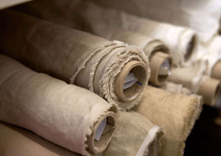 Close-up set of linen textile rolls. Online sale or tailoring objects concept. Fabrics retail store, atelier, drapery or textile shop. High quality imageの写真素材