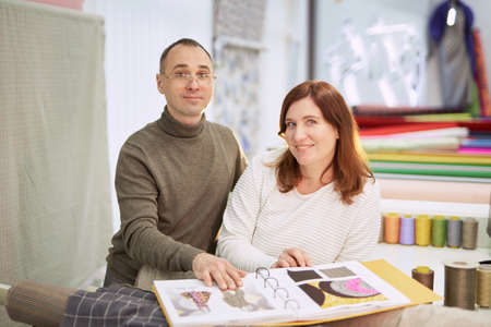 Couple of two professional tailors or drapery store owners looking at camera smiling. Family...