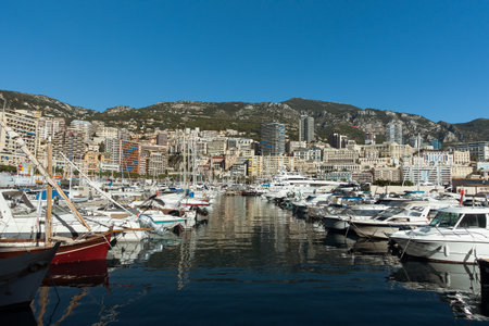 Monaco - 18.10.2018. Luxury yachts in the Monaco harbor with large apartment complexes on background. Mediterranean yacht marina in Monaco sea port, Monaco and Monte Carlo principalityのeditorial素材