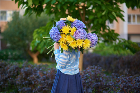 women holding a bouquet of blue hydrangea on the background of green garden , spring concept. High quality photoの写真素材