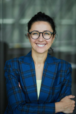 Portrait of a business woman with glasses smiling and happy. Dark blue jacket, confident woman looking in the camera High quality photoの写真素材