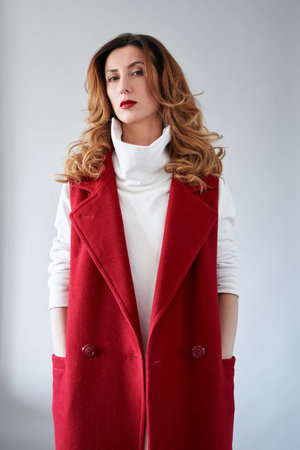 Portrait of stylish caucasian brunette woman with wavy hair and brown eyes in an elegant burgundy suit Confident style, serious businesswoman concept. High quality vertical photoの写真素材