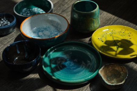 Set of kitchen ceramic tableware and wooden cutting boards on a table. Eco style home still life. High quality photoの写真素材