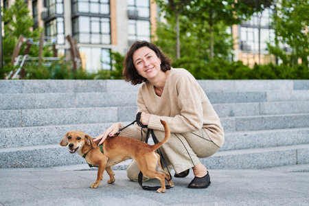 Girl kissing hugging dog pet cute adorable red dog friendly closeup closing eyes funny animals. High quality photoの写真素材
